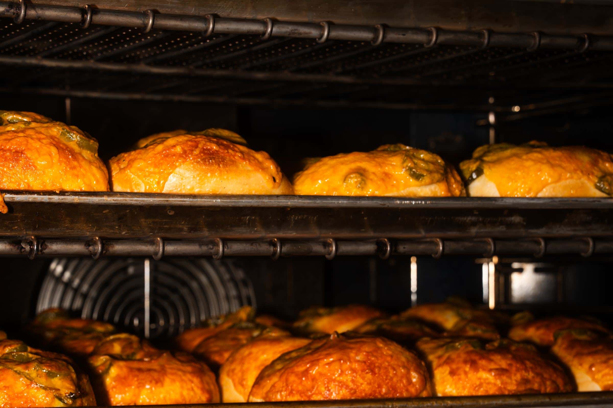 Jalapeño cheddar bagels baking on the oven racks